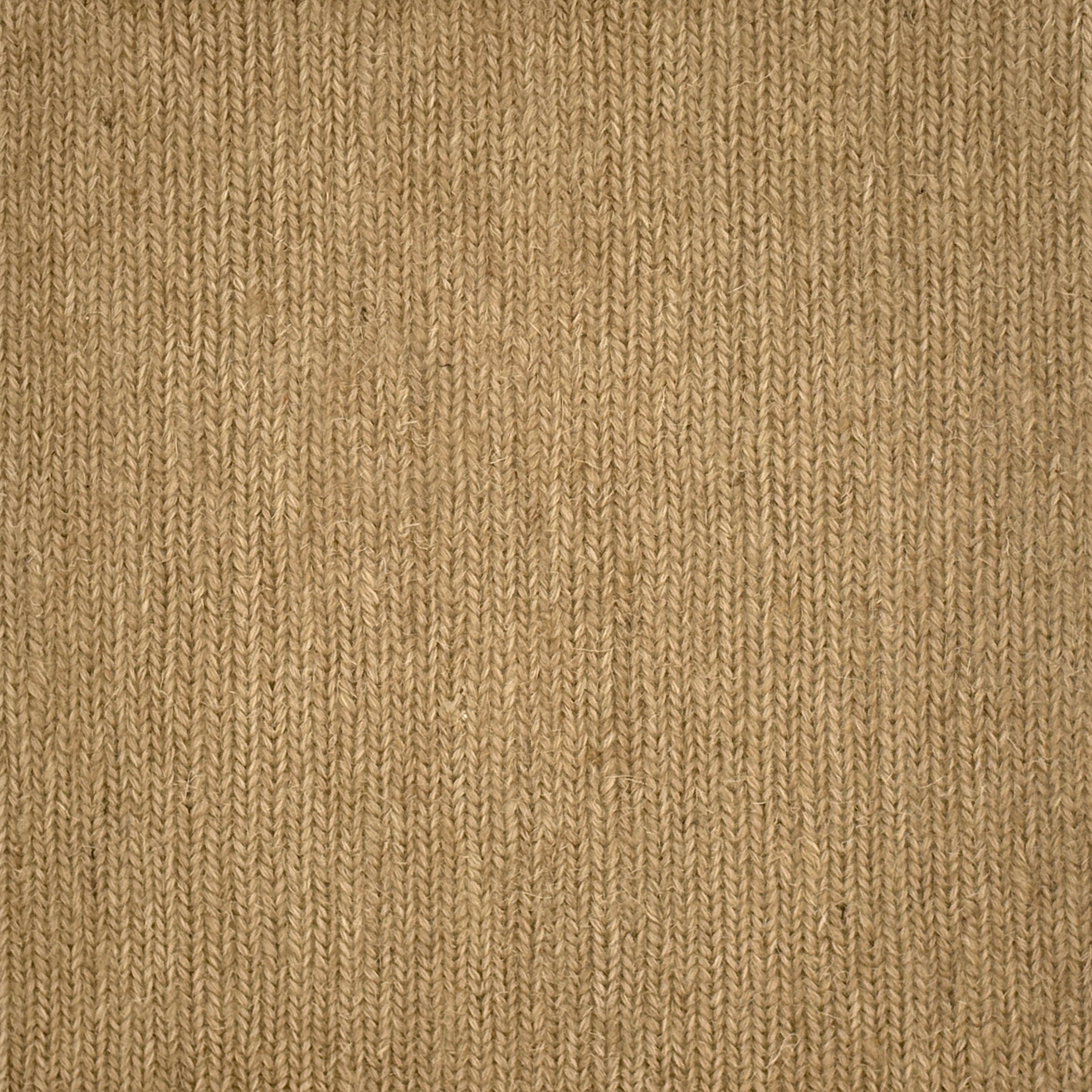 Close up of a carpet with a herringbone weave in tan. 
