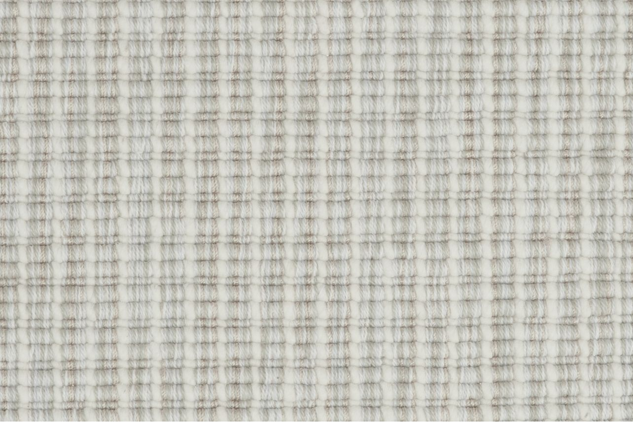 Broadloom carpet in a ribbed striated stripe in shades of cream and beige.