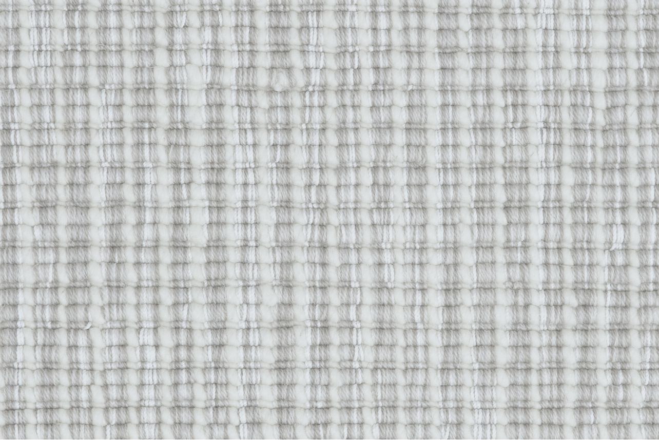 Broadloom carpet in a ribbed striated stripe in shades of cream and light grey.