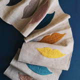 Draped linen with colorful embroidered lips on a blue background. 
