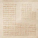 Flatwoven rug with a raised border corner design in cream.