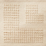 Flatwoven rug with a raised border corner design in cream.