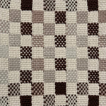 Close-up of a textured checkered rug with brown, gray, and beige squares.