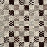 Close-up of a textured checkered rug with brown, gray, and beige squares.