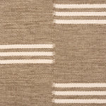 Broadloom flatweave carpet in a broken stripe in white on a brown field. 