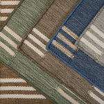 Stacked broadloom carpet samples in a handsome stacked stripe pattern in various colors. 