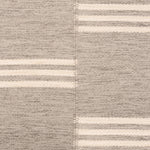 Broadloom flatweave carpet in a broken stripe in white on a grey field.