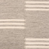 Broadloom flatweave carpet in a broken stripe in white on a grey field.