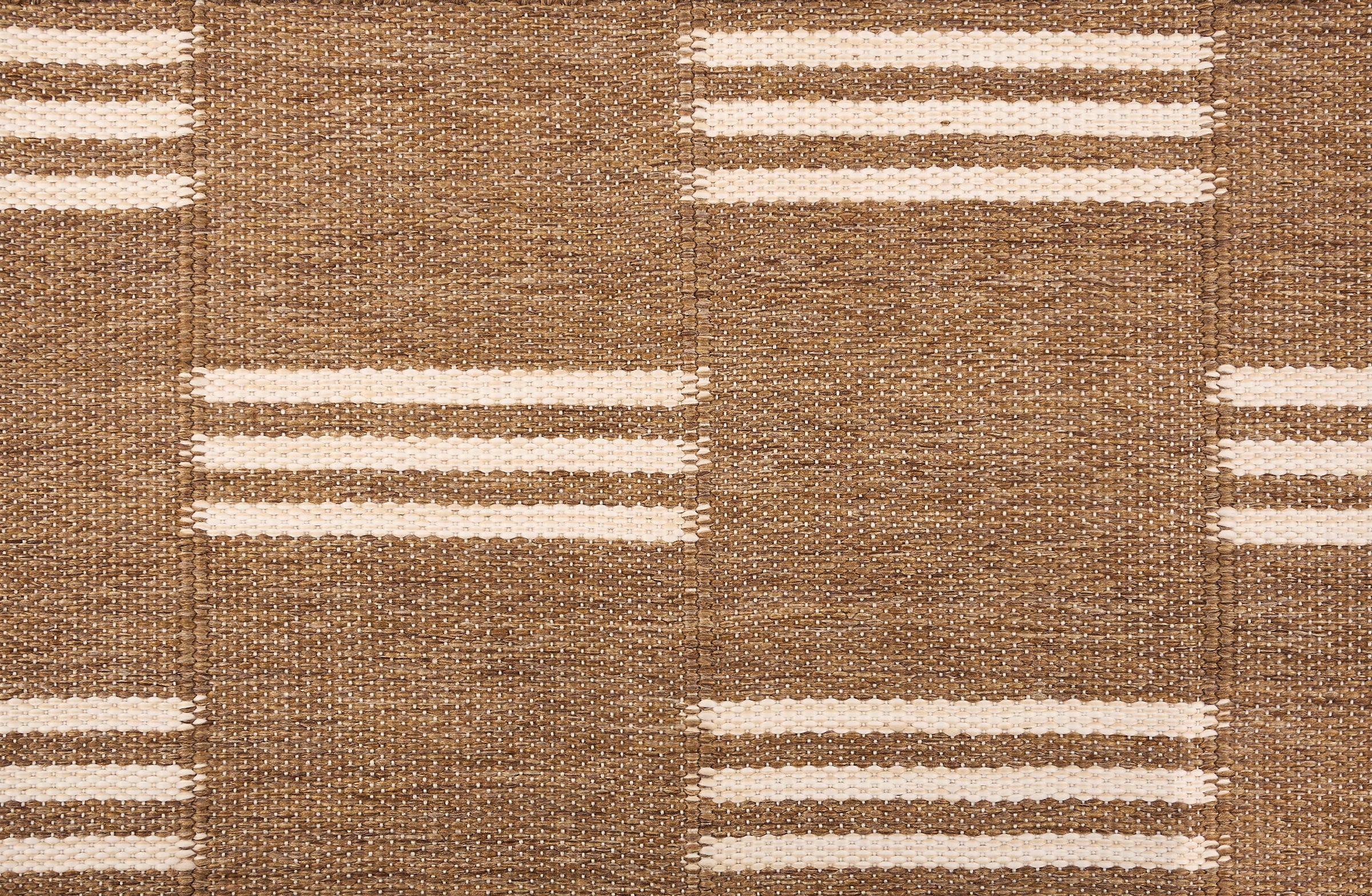 Broadloom flatweave carpet in a broken stripe in white on a brown field.