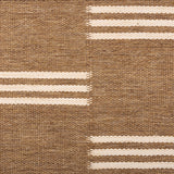 Broadloom flatweave carpet in a broken stripe in white on a brown field.
