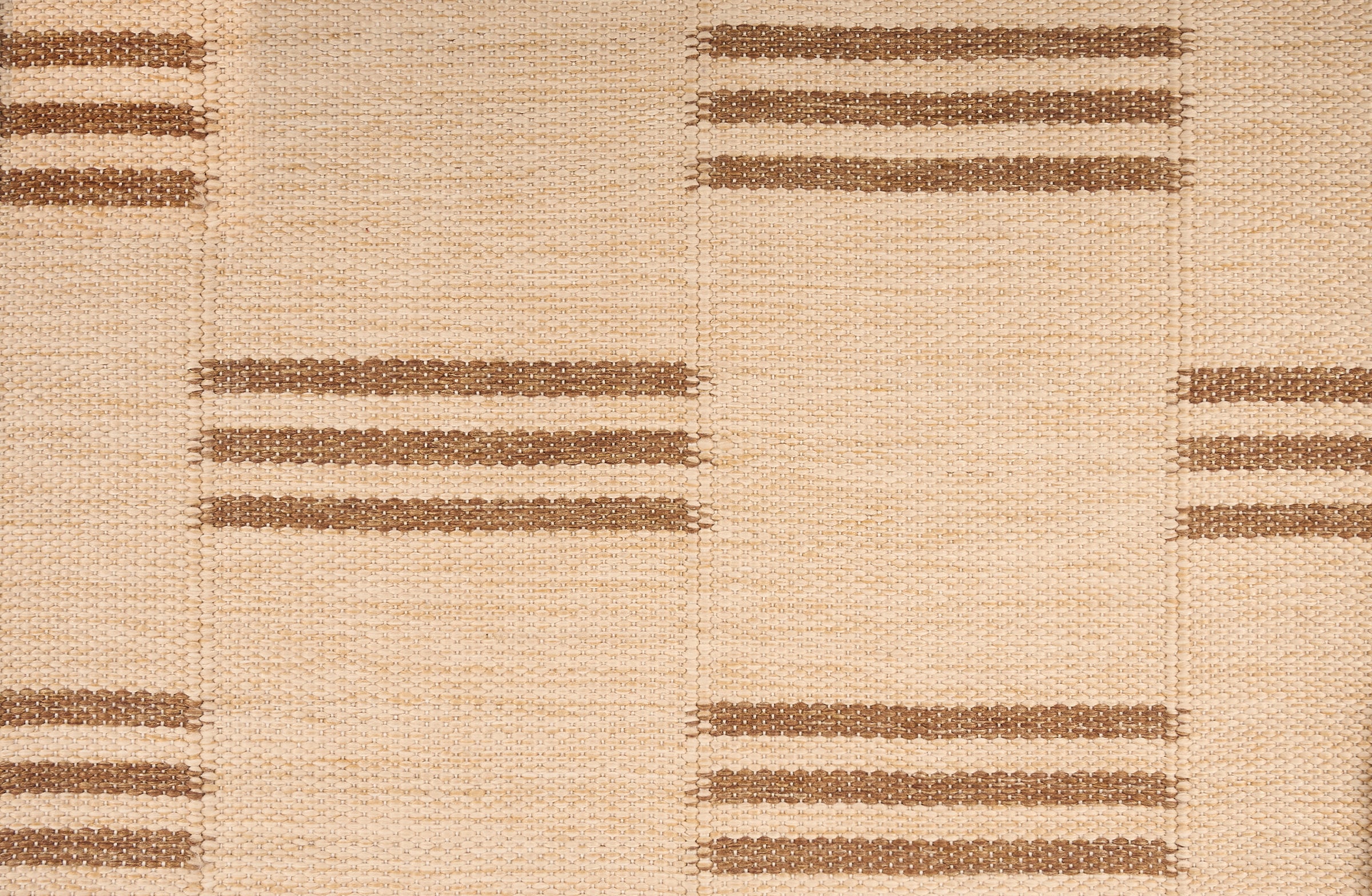 Broadloom flatweave carpet in a broken stripe in brown on a beige field.