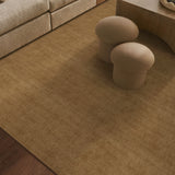 Beige rug on a wooden floor with two mushroom-shaped stools in a living room setting.