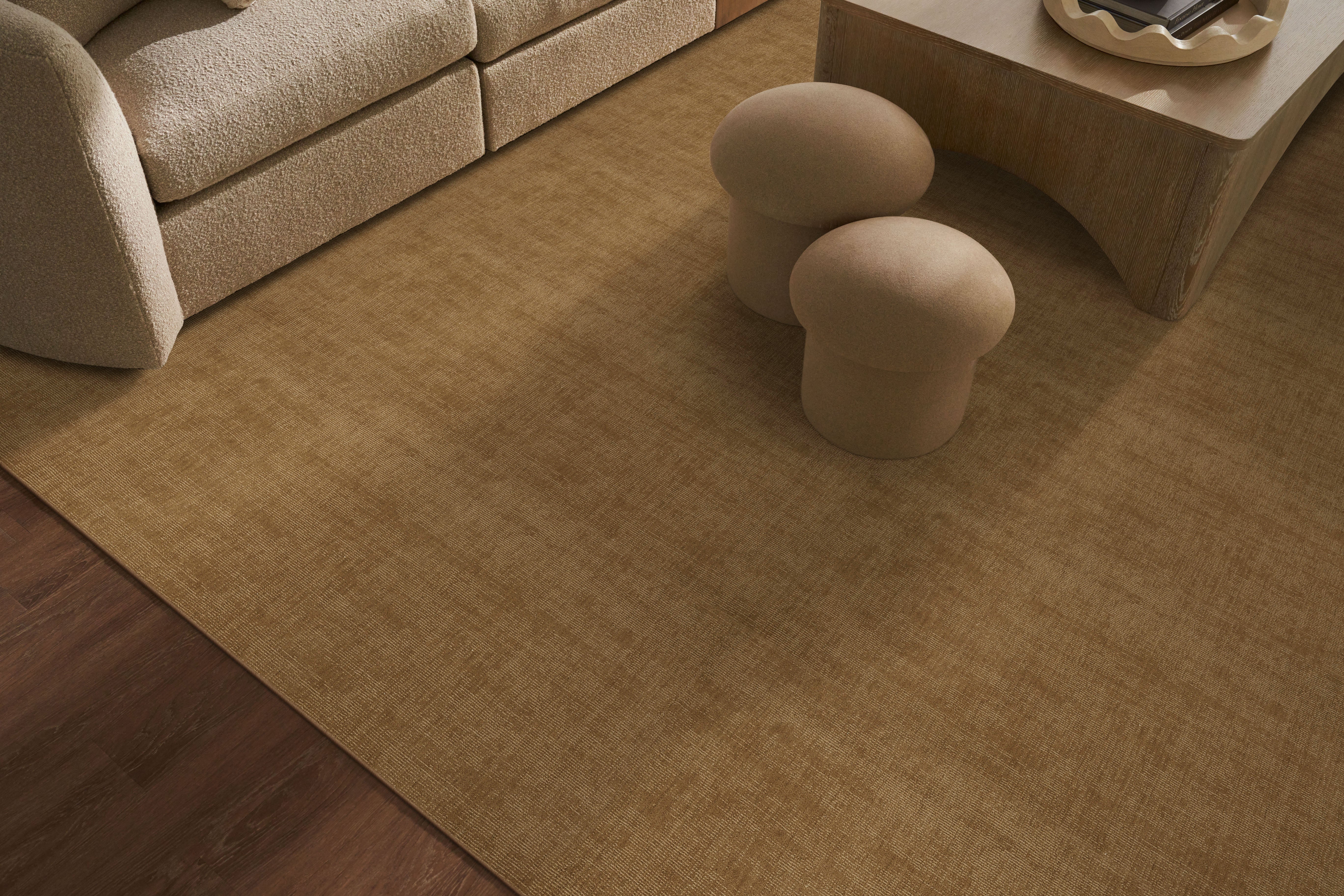 Beige rug on a wooden floor with two mushroom-shaped stools in a living room setting.