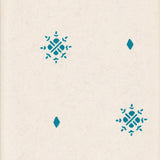 Detail of wallpaper in a repeating geometric starburst print in turquoise on a cream field.