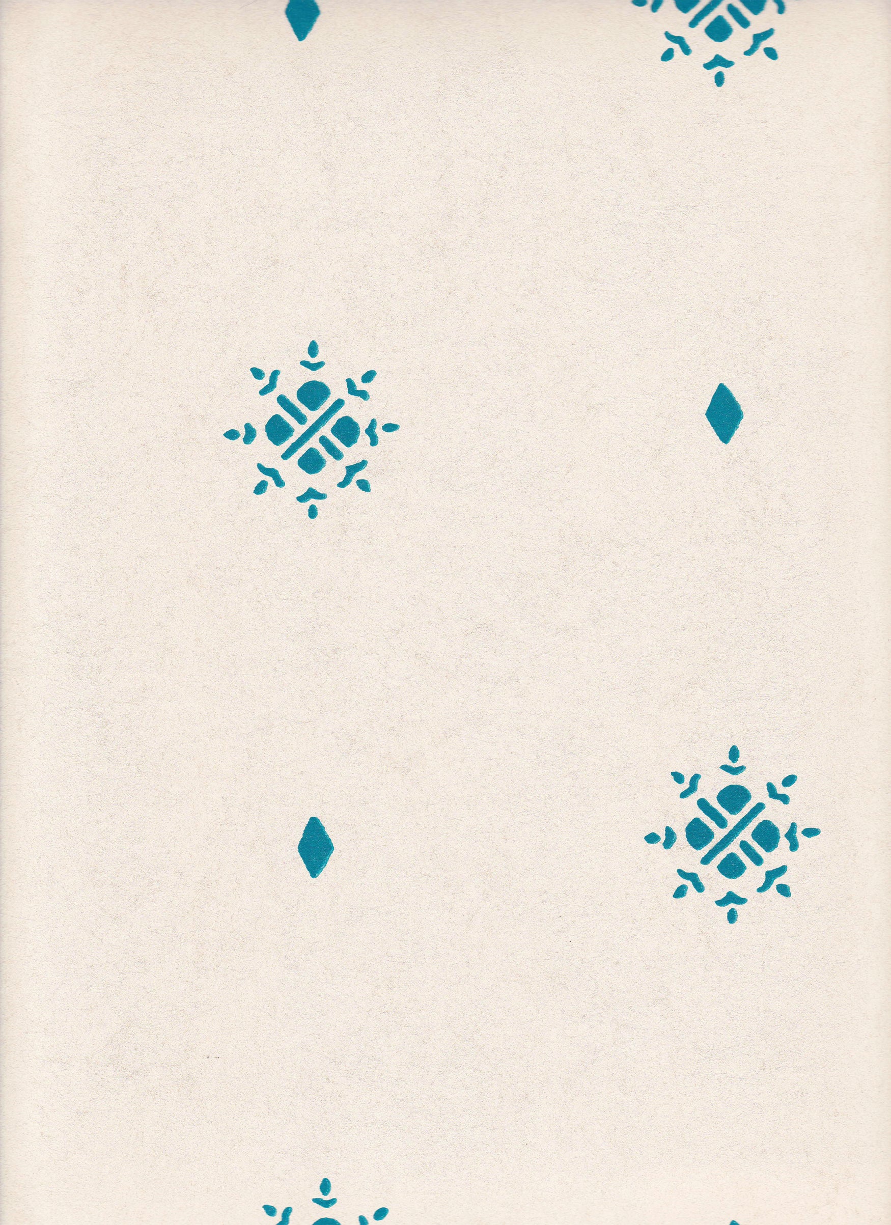 Detail of wallpaper in a repeating geometric starburst print in turquoise on a cream field.