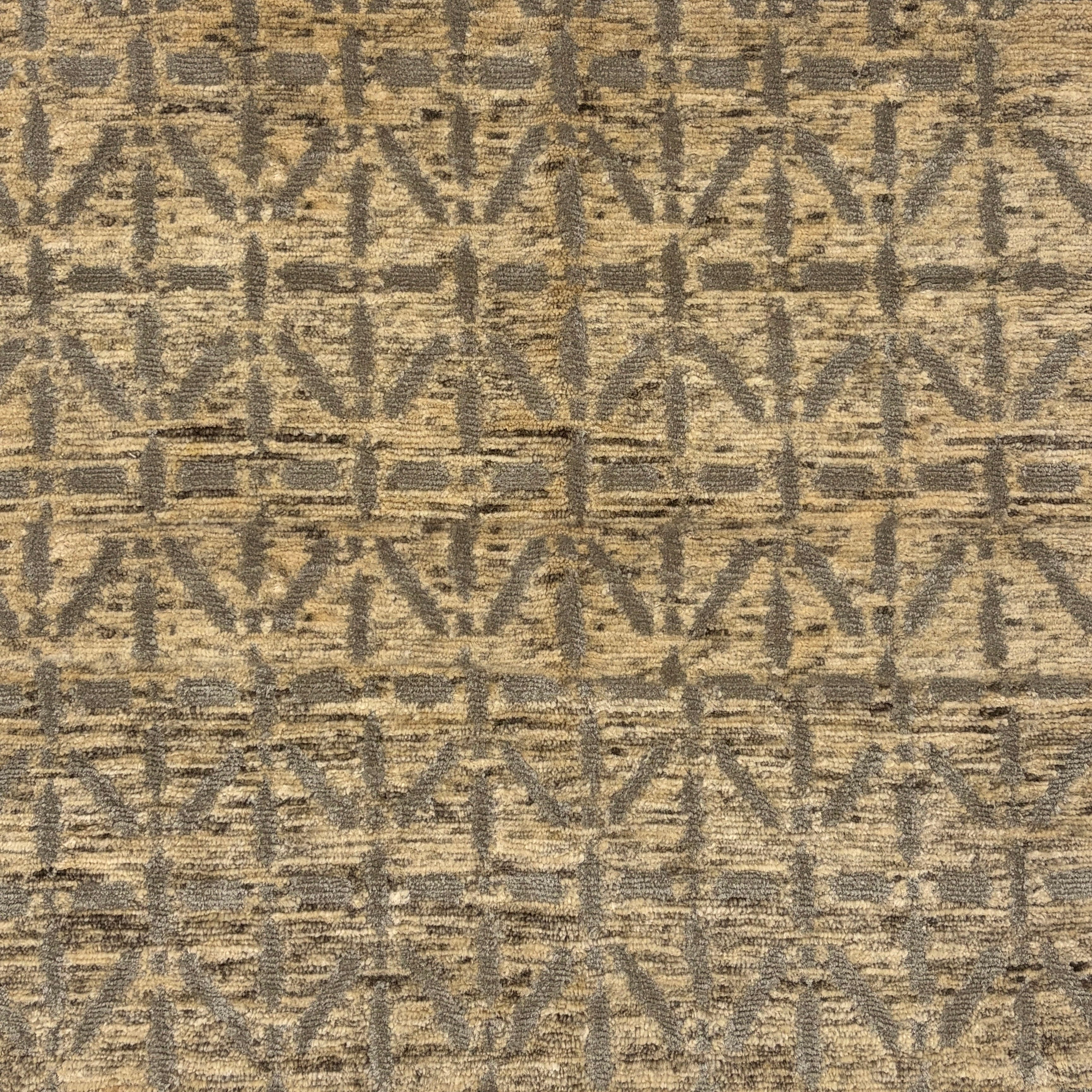 Handknotted rug with linear star design in grey on a mottled beige field. 