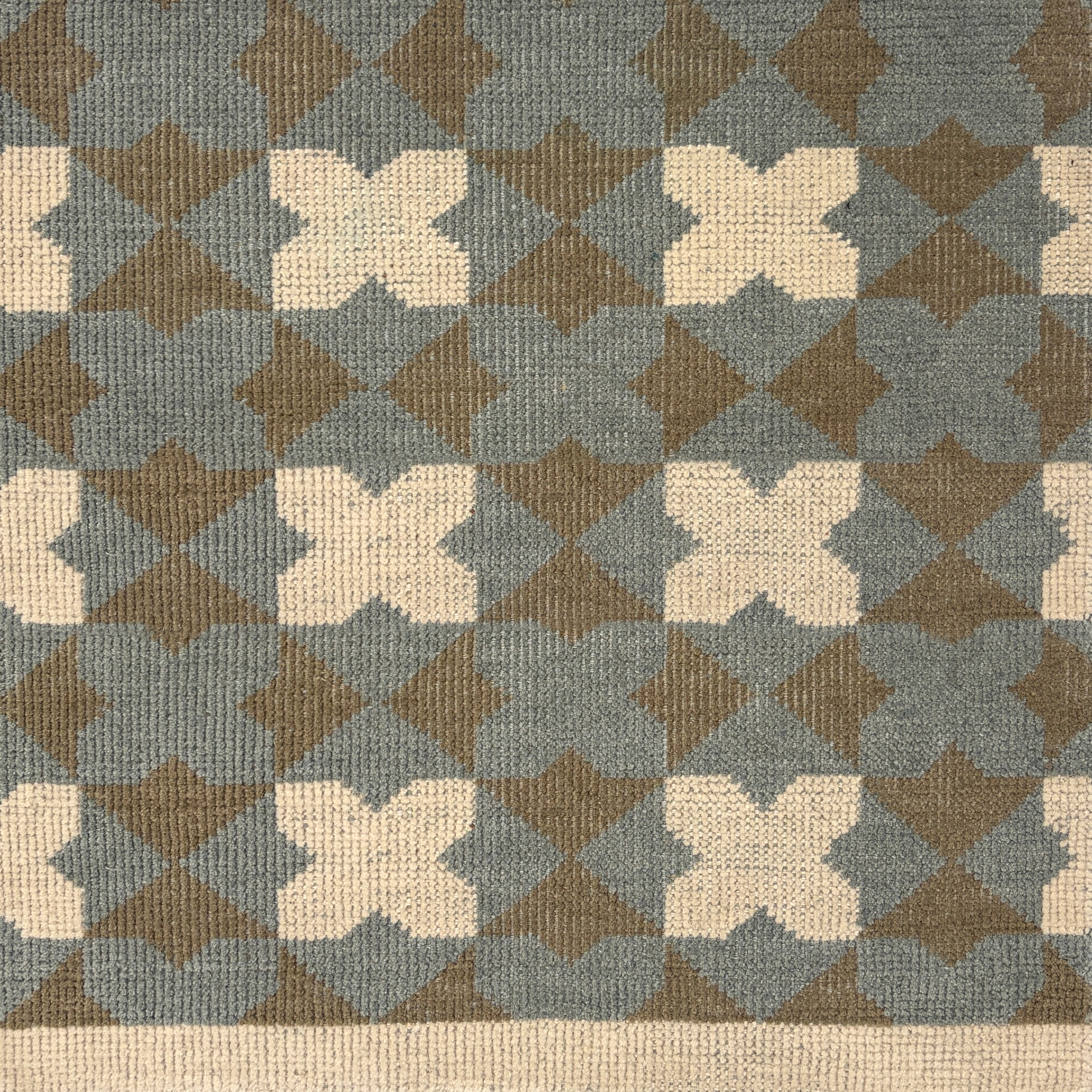 Handknotted rug with geometric mosaic design in slate blue, grey and cream. 