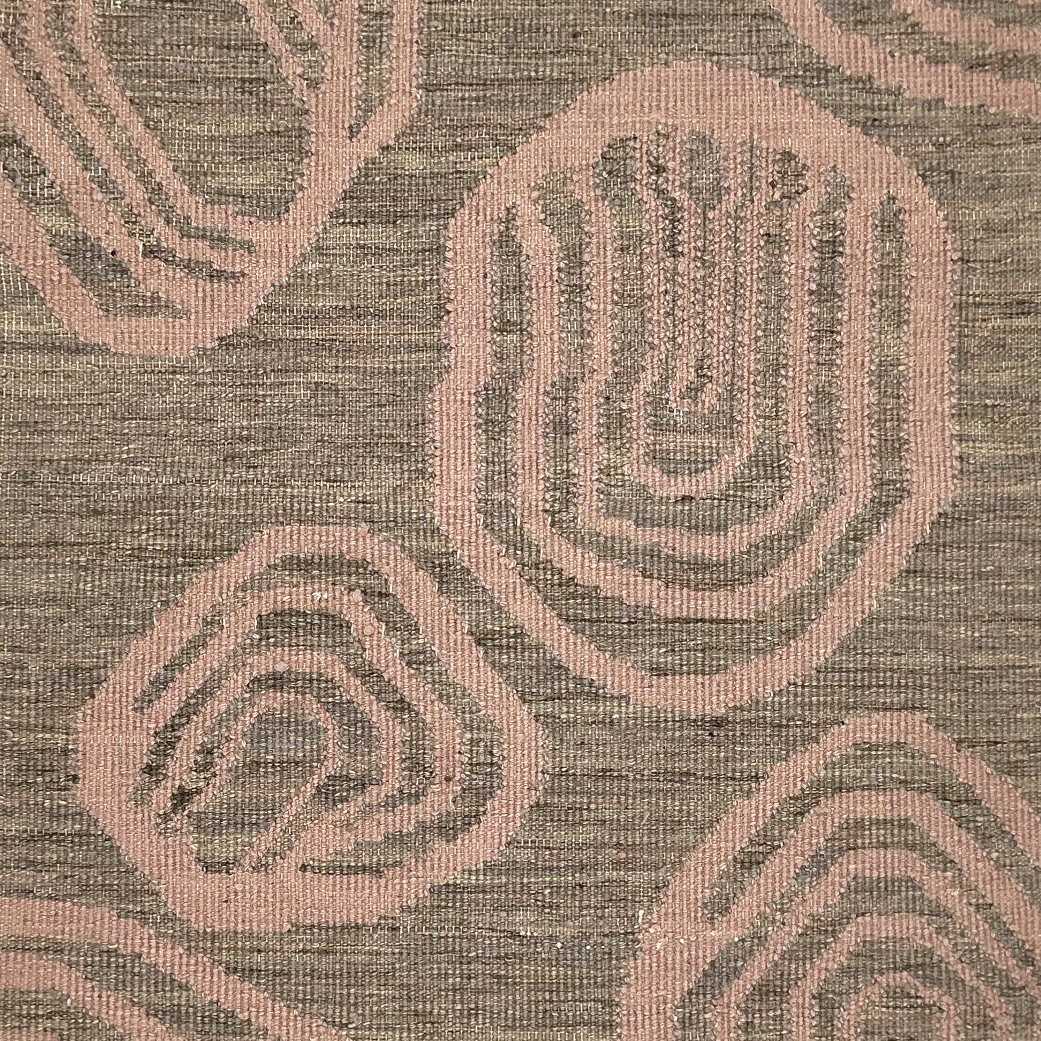 Handwoven rug with geometric pattern in grey and pink tones