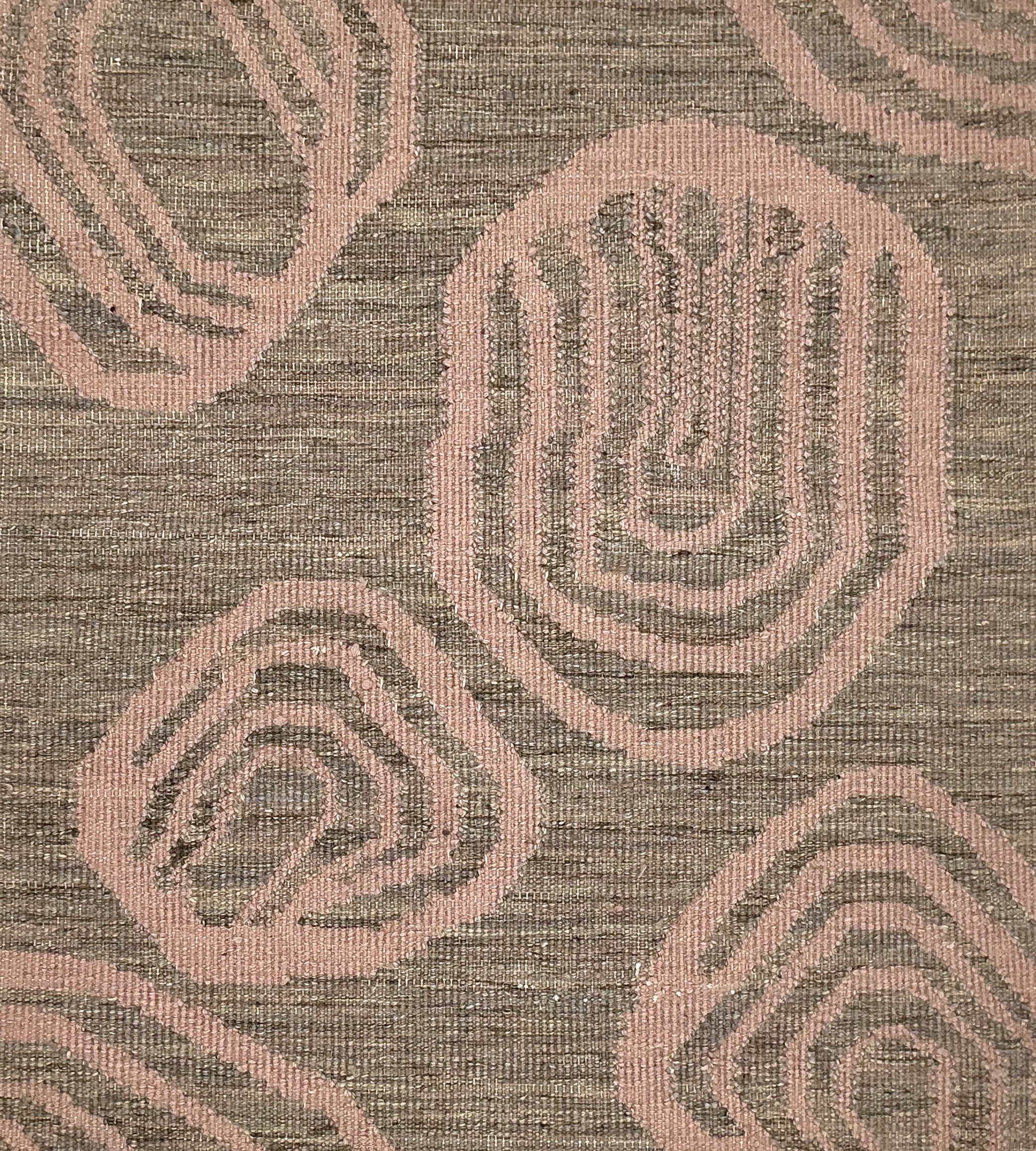 Handwoven rug with geometric pattern in grey and pink tones