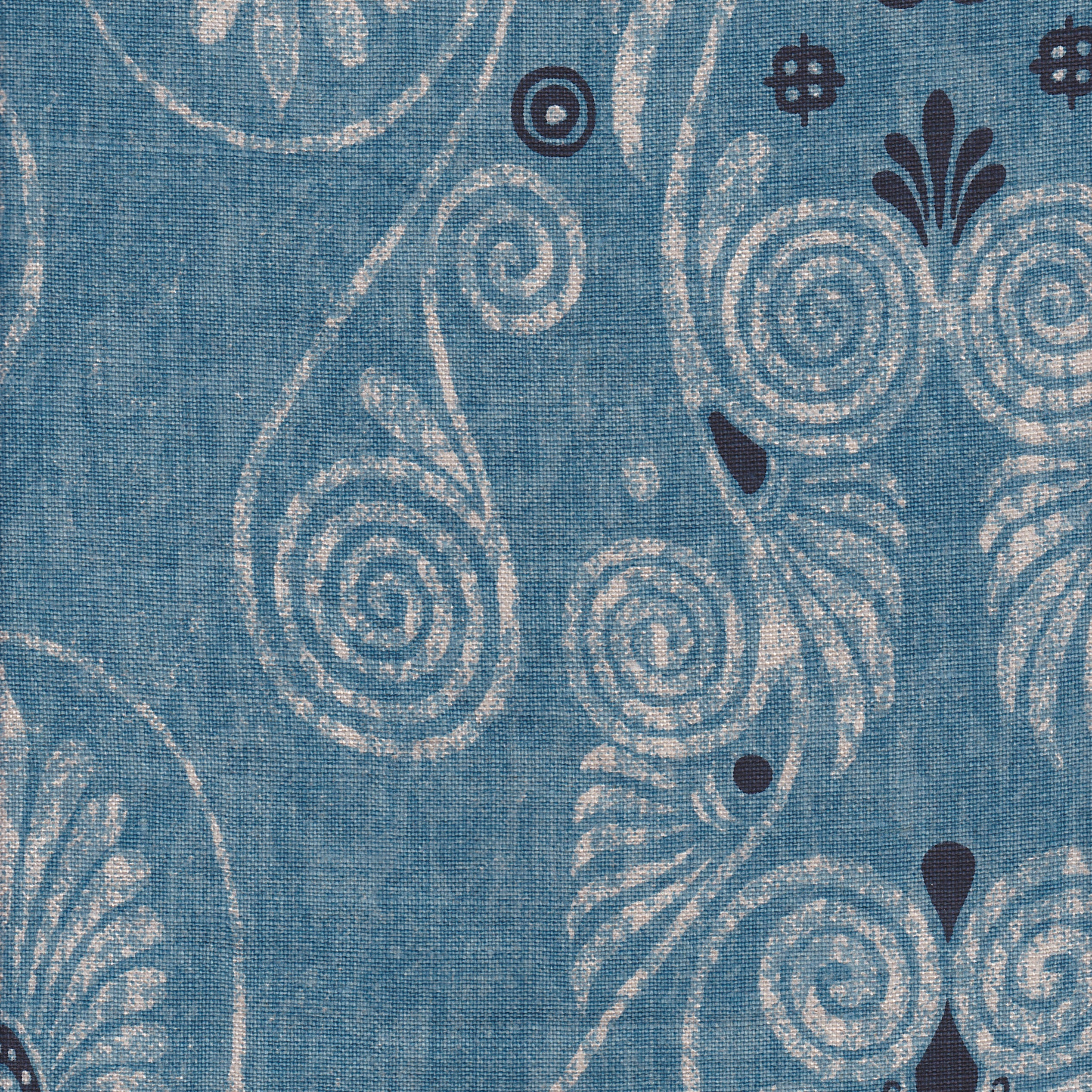Detail of fabric in a damask print in shades of tan and navy on a blue field.