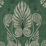 Detail of fabric in a damask print in shades of dark green and cream on a green field.