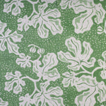 Detail of fabric in a playful botanical print in light green and white on a green field.