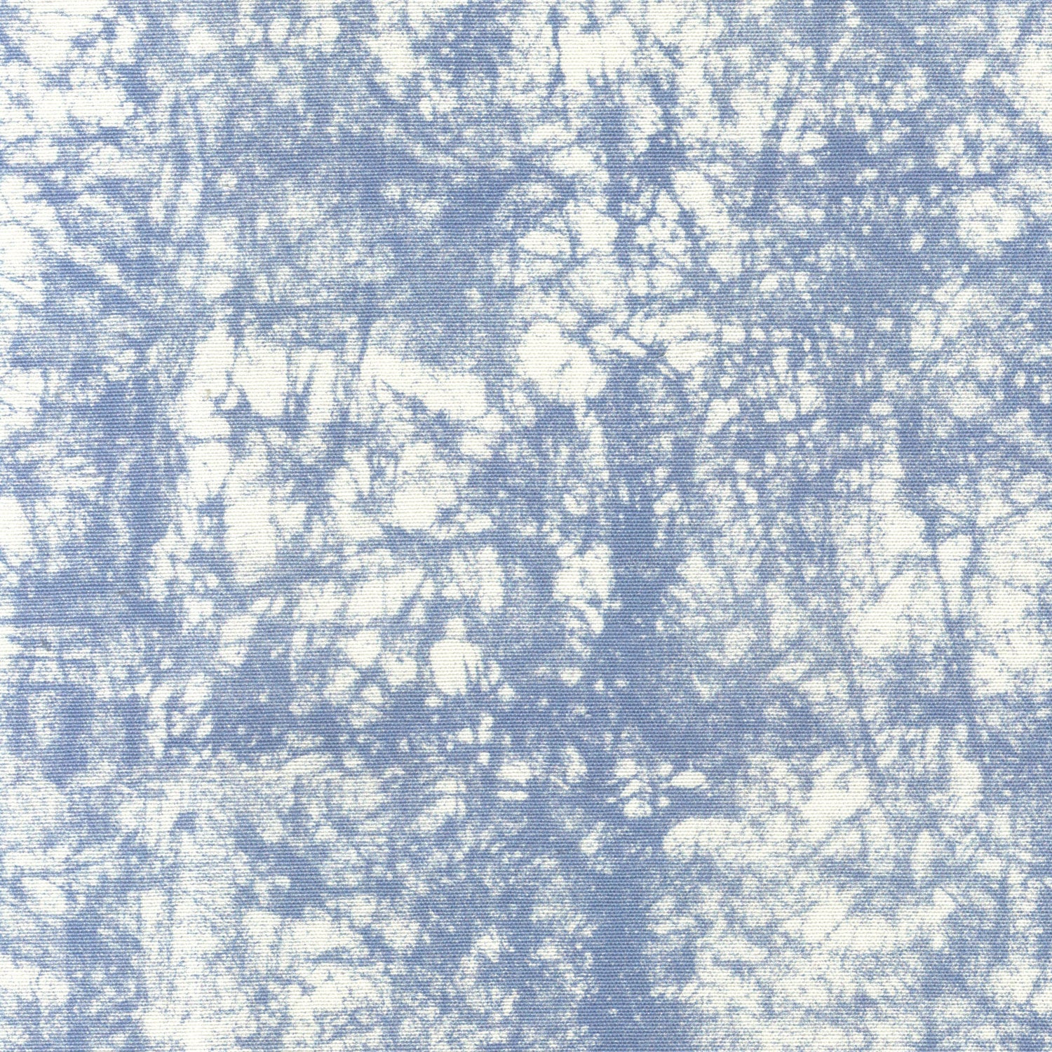 Detail of fabric in a textural splatter print in blue on a cream field.