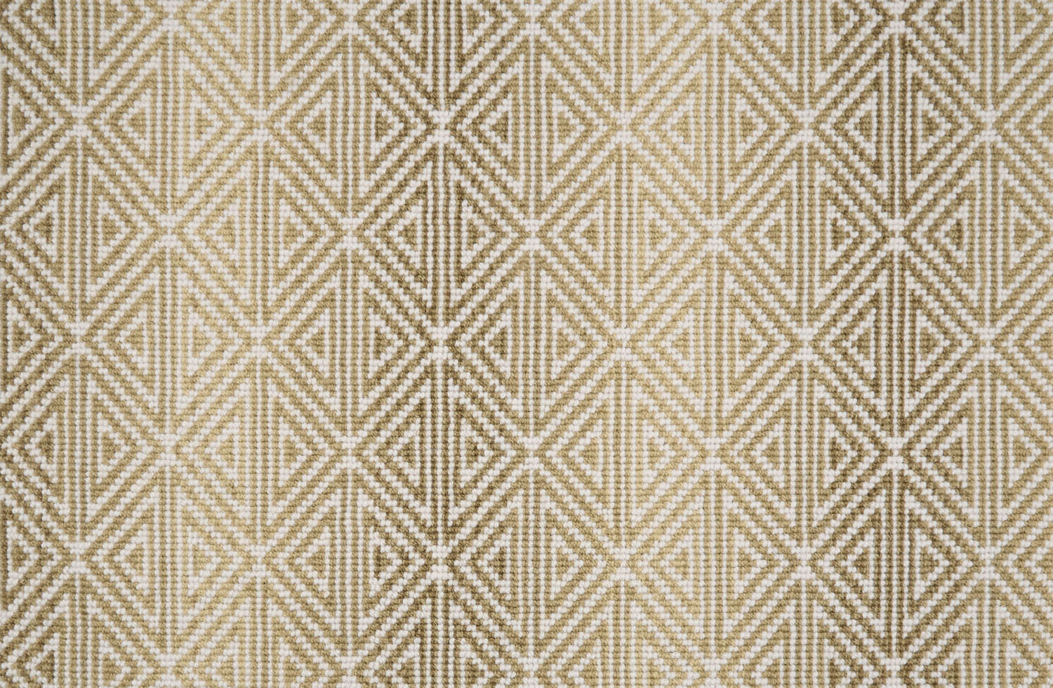 Broadloom carpet with triangle pattern with an ombré background in shades of tan.