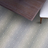 Patterned rug with a wooden table and chair on a geometrically designed floor.