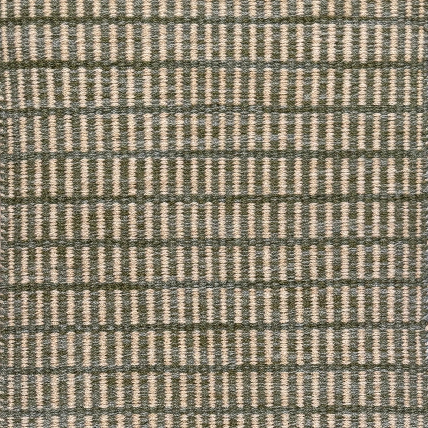 Textured rug with a sage green and beige  checker pattern