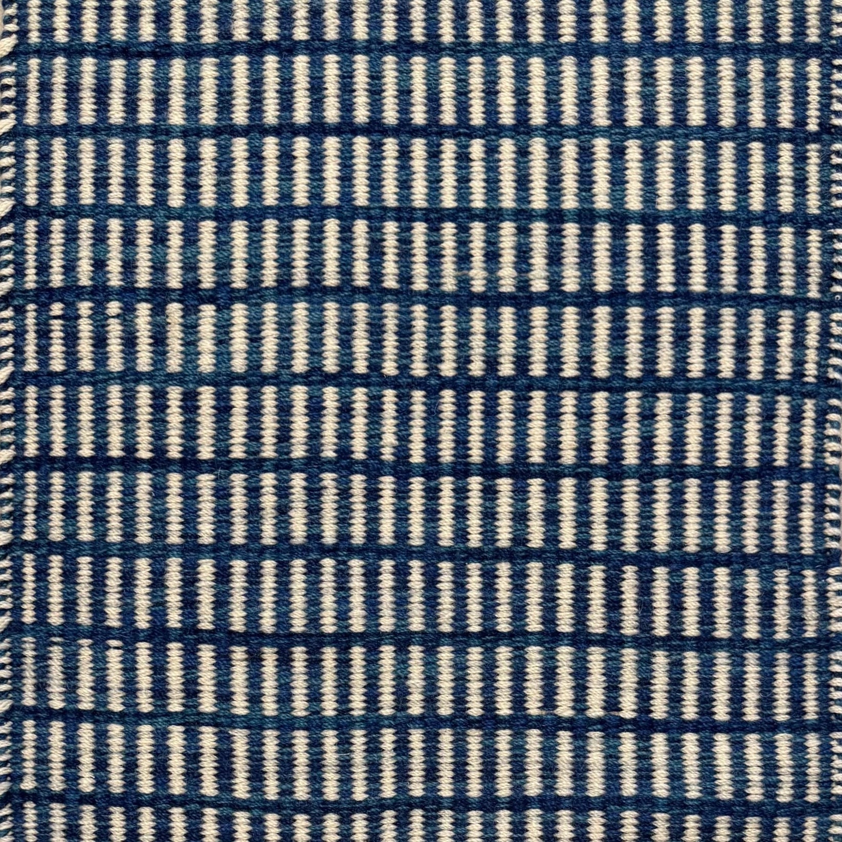 Textured rug with a blue and ivory checker pattern