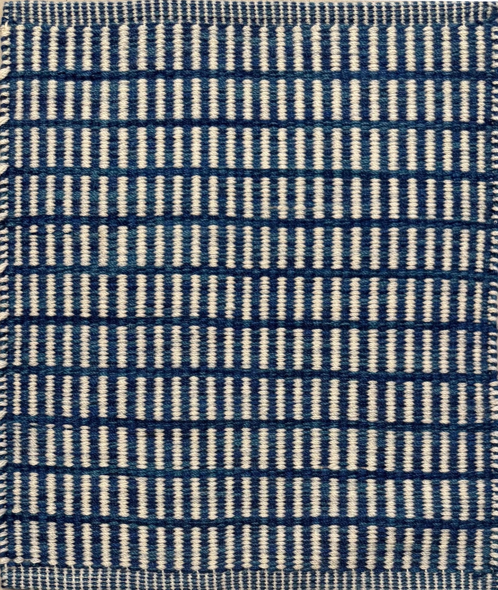 Textured rug with a blue and ivory checker pattern