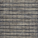 Textured rug with a striated navy blue and cream checker pattern