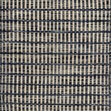 Textured rug with a striated navy blue and cream checker pattern