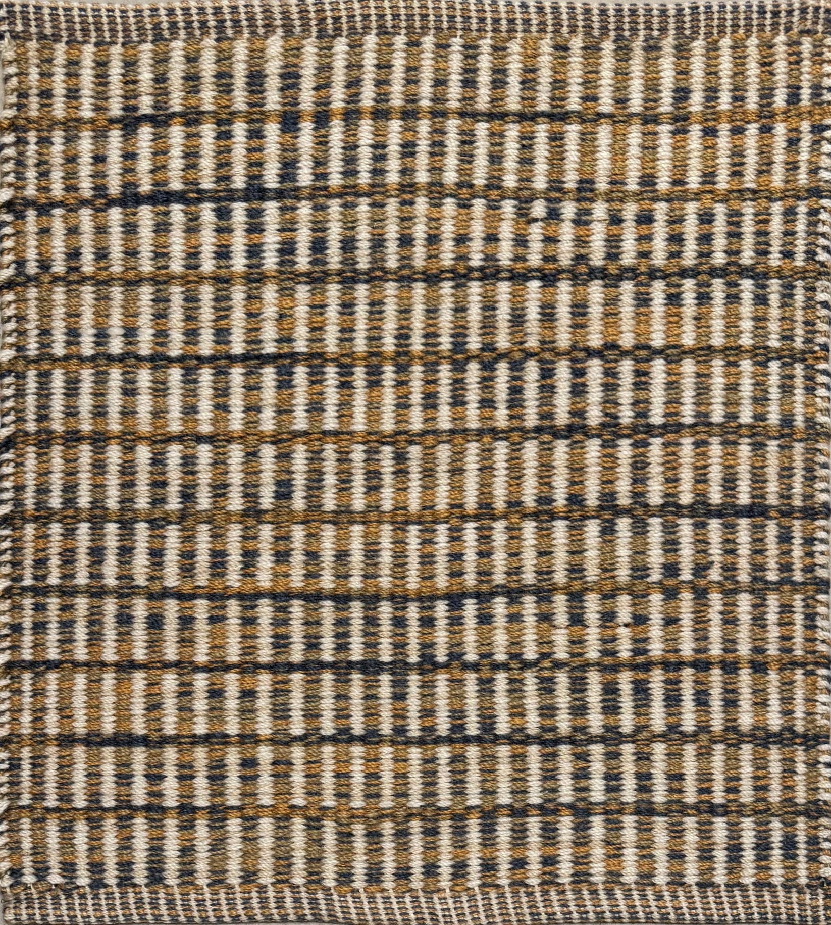 Textured rug with a navy, tan and beige  checker pattern