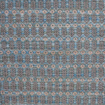Handwoven wool rug with an oval and diamond lattice pattern in shades of blue and brown with clay pink accents.