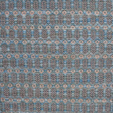 Handwoven wool rug with an oval and diamond lattice pattern in shades of blue and brown with clay pink accents.