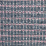 Handwoven wool rug with an oval and diamond lattice pattern in shades of grey and dark blue with pink accents.
