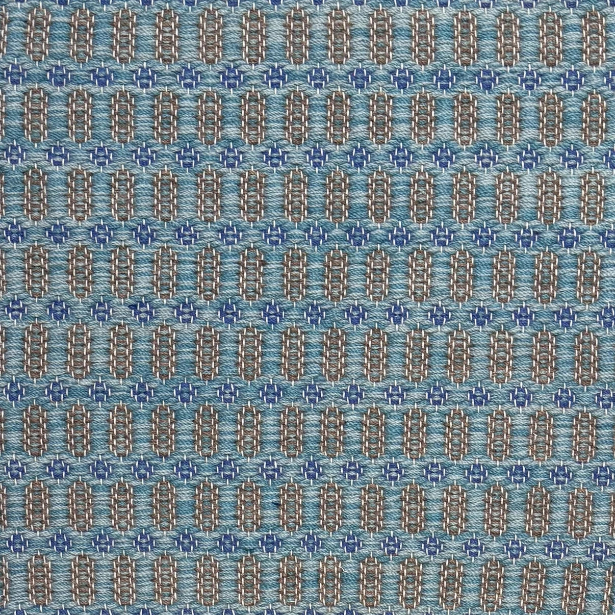 Handwoven wool rug with an oval and diamond lattice pattern in shades of turquoise and brown with blue accents.