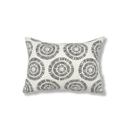 Rectangular throw pillow in a circular dot pattern made of small dashed lines in grey printed on white linen.