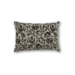 Rectangular throw pillow with a floral scroll filigree pattern in black against a natural linen background. 