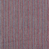 Dimensional embroidered fabric in an irregular stripe pattern in shades of gray, white, pink and blue.