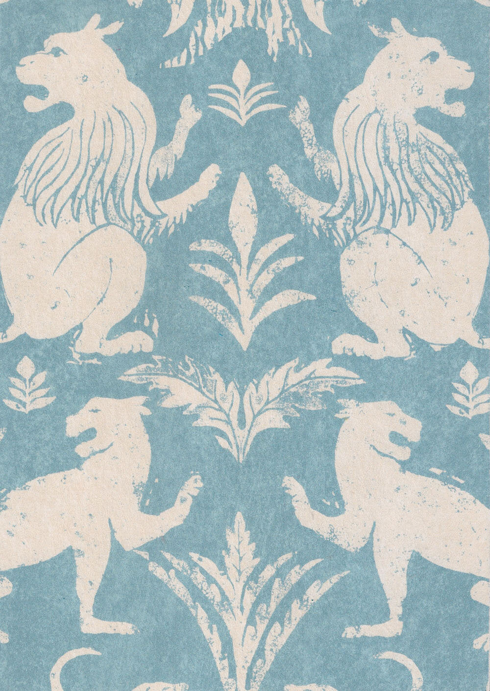 Close-up of fabric in a lion and plant print in cream on a light blue field.