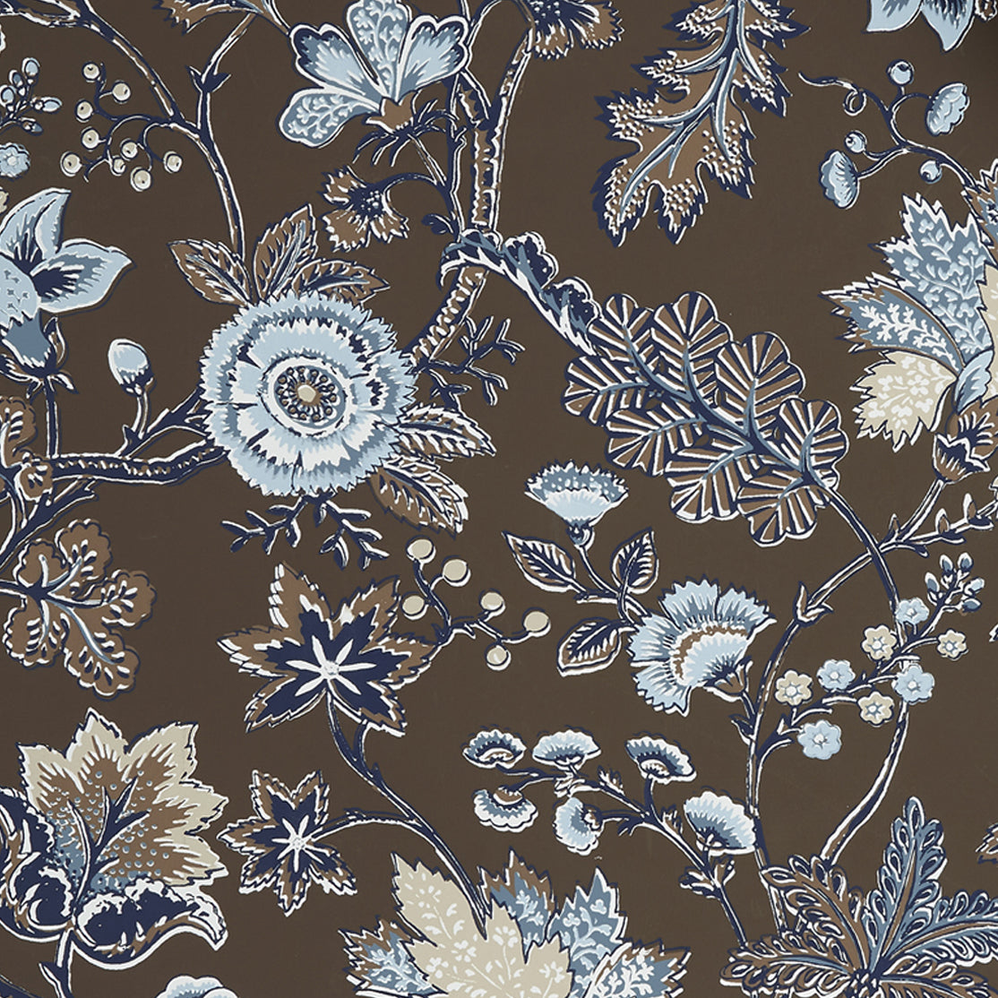 Close up of wallpaper in scrolling floral vine pattern in shades of blue, tan and taupe on a chocolate brown field. 