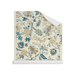 Roll of wallpaper in scrolling floral vine pattern in tan, taupe and shades of blue on cream. 