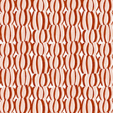 Detail of fabric in an abstract curvilinear print in red and pink on a white field.