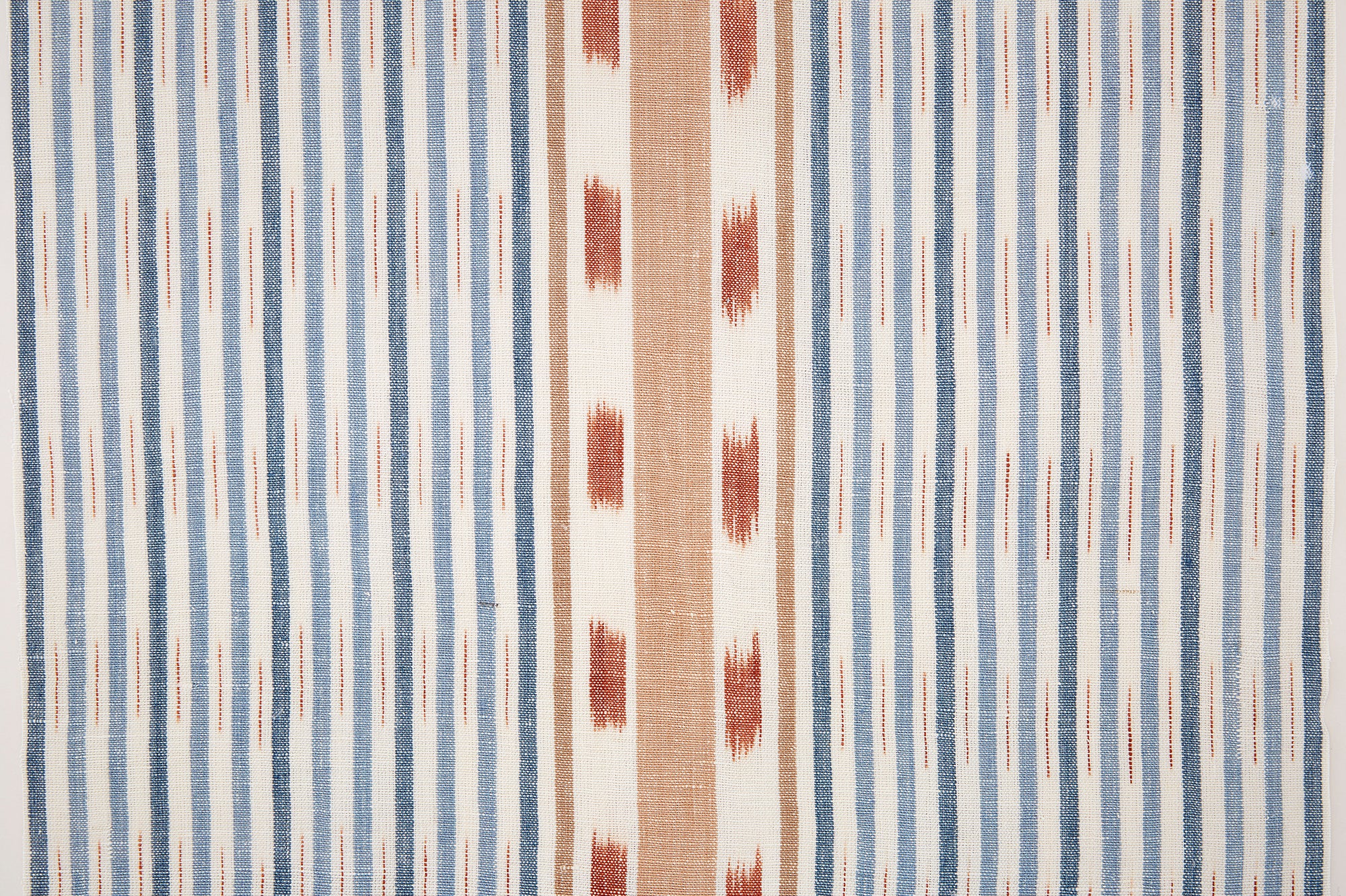 Detail of fabric in a global stripe print in blue, orange and rust on a white field.