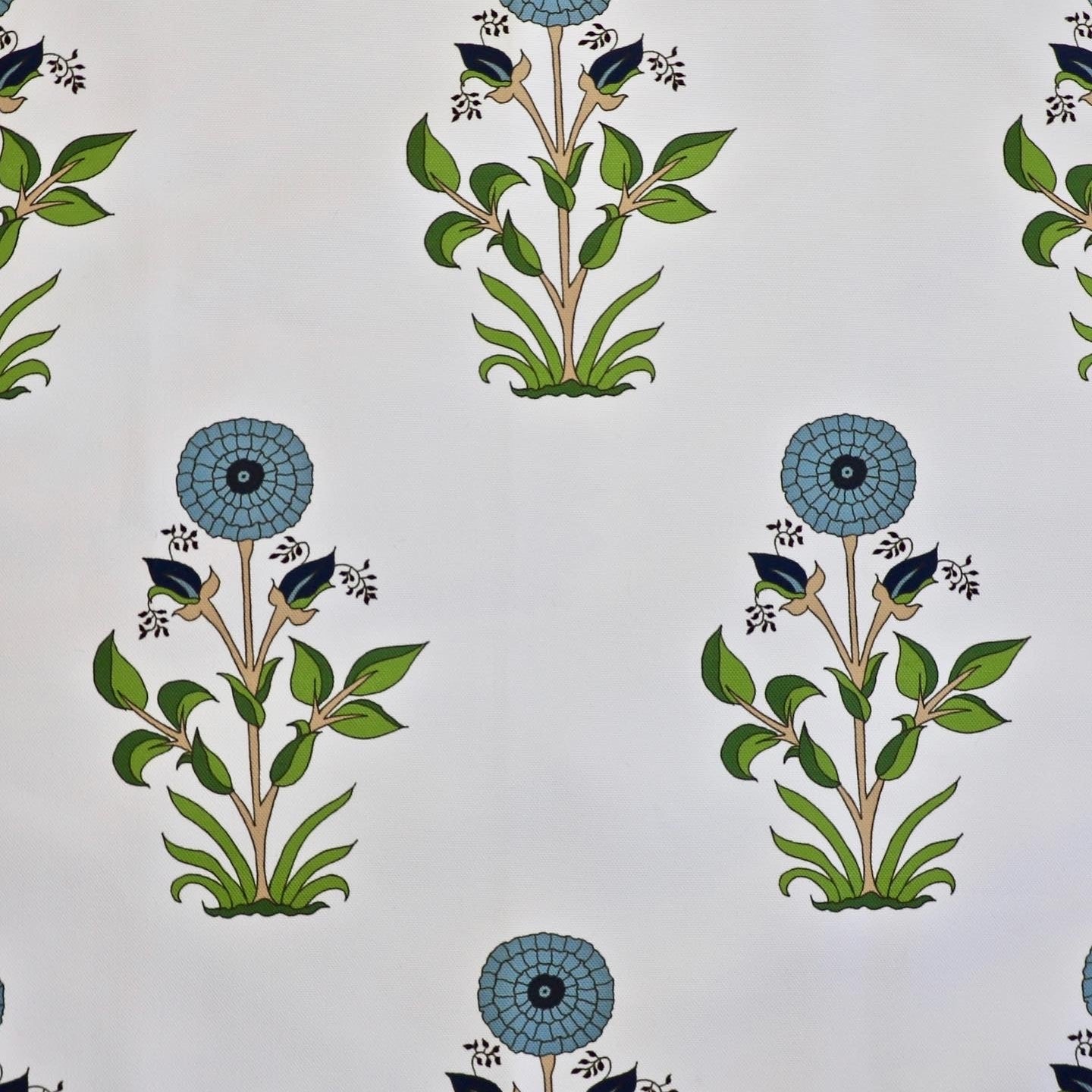 Detail of fabric in a large-scale marigold print in blue, orange and green on a white field.