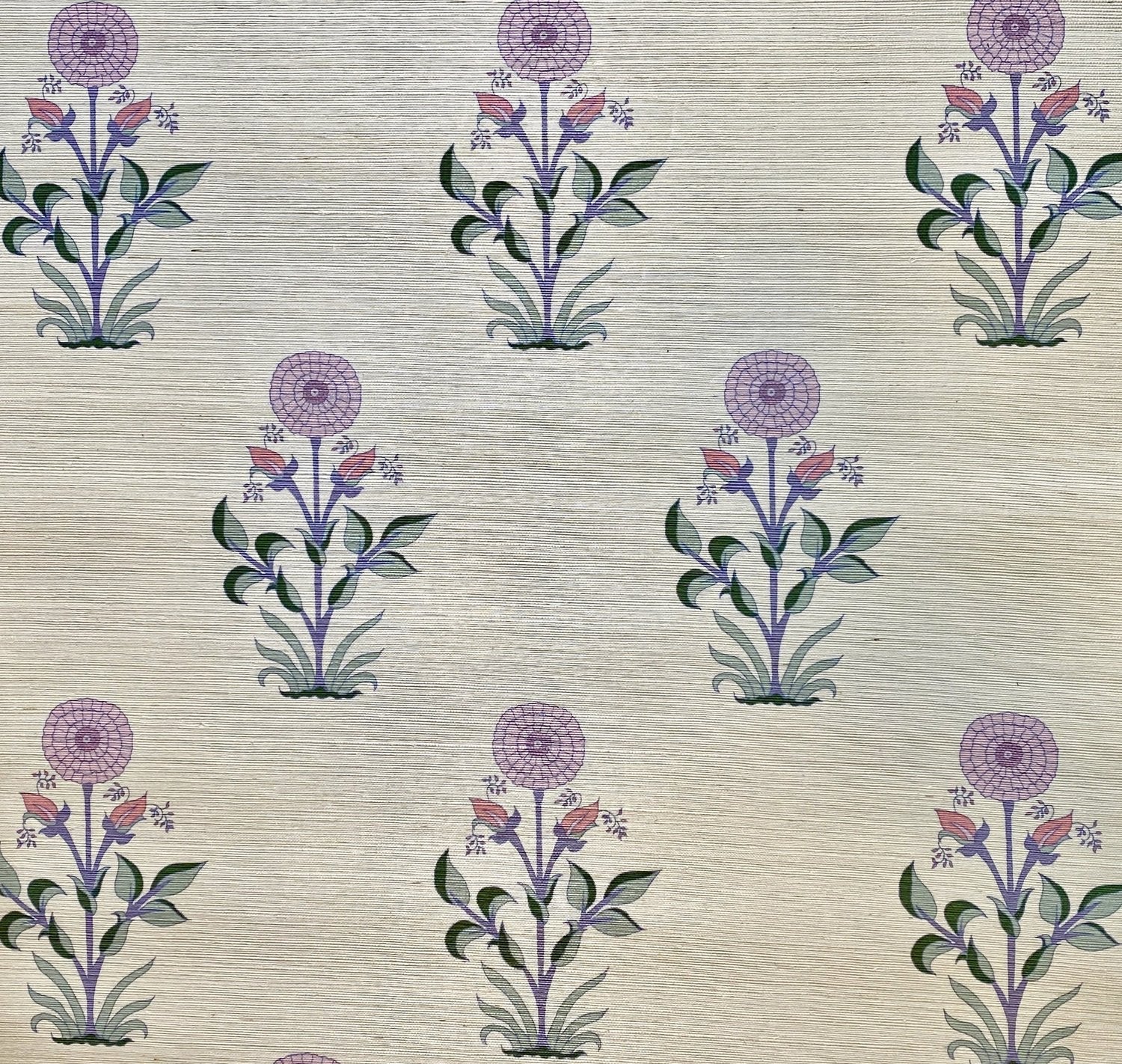 Detail of fabric in a large-scale marigold print in purple, pink and green on a tan field.
