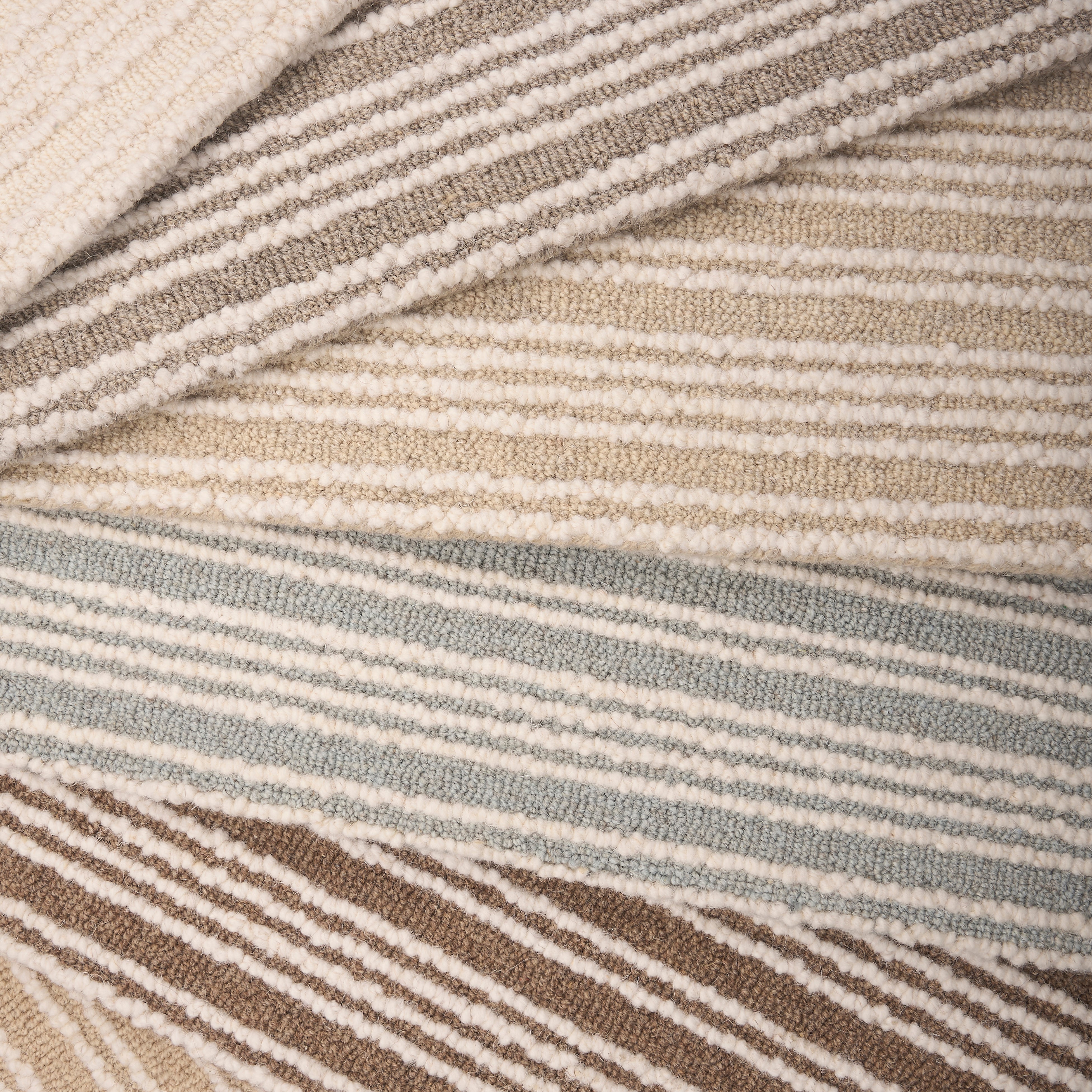 An array of striped broadloom carpets in neutral colors 